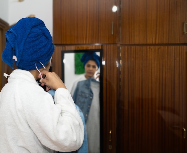 jeune femme devant le miroir regardant les vêtements à mettre