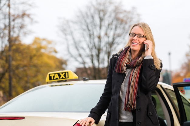 Jeune Femme Devant Un Taxi Avec Téléphone