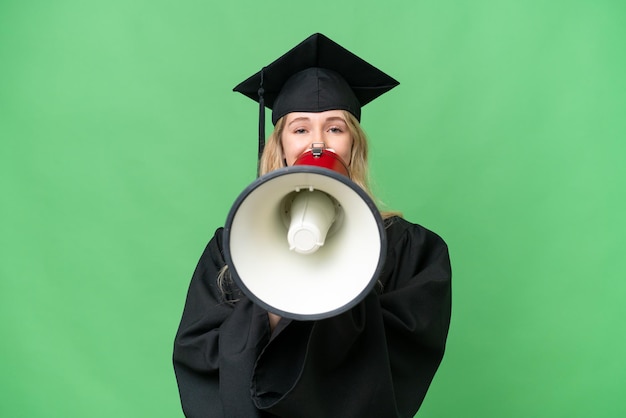 Jeune femme diplômée en anglais de l'université sur fond isolé criant à travers un mégaphone