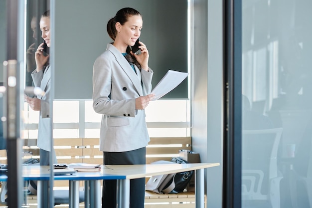 Jeune femme directrice d'entreprise parlant sur téléphone mobile