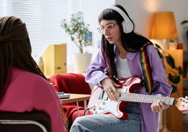 Jeune femme discutant d'une nouvelle chanson avec son amie pendant la répétition