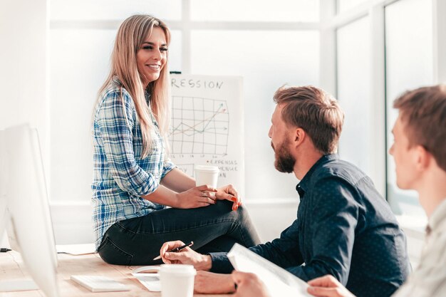 Jeune femme discutant avec ses collègues d'une nouvelle stratégie. le concept de travail d'équipe