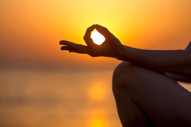 Jeune femme doigts dans le yoga Jnana mudra close up copy space Méditation de relaxation sur la mer au coucher ou au lever du soleil