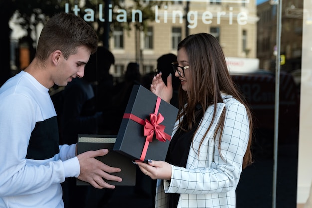 Jeune femme donne un cadeau à l'amant. Fille donne un cadeau à un ami.