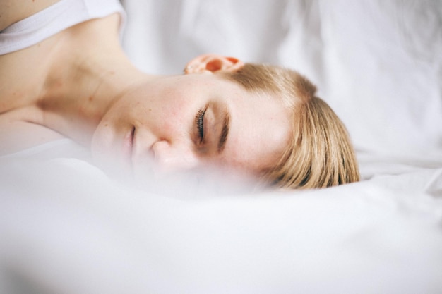 Une jeune femme dort dans son lit.