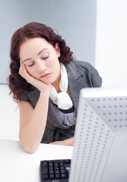 Jeune femme dort devant un ordinateur