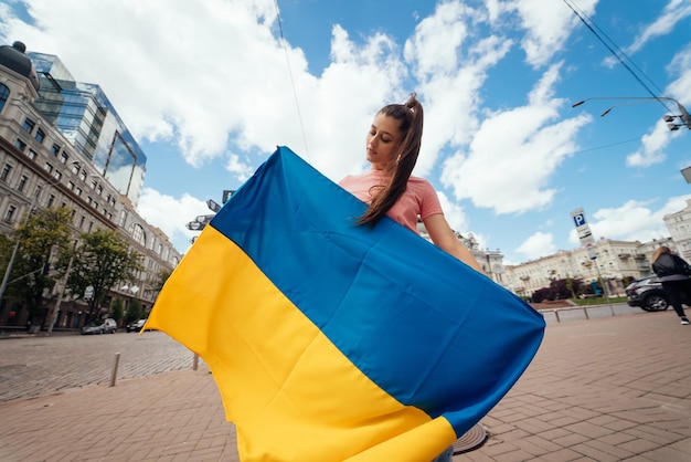 Jeune femme avec le drapeau national de l'Ukraine dans la rue