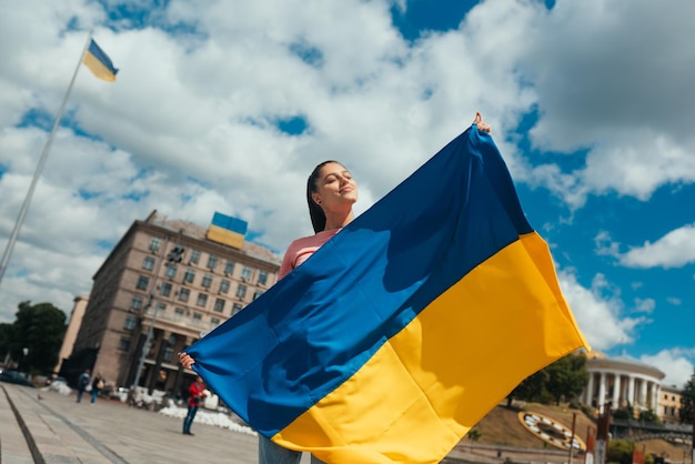 Jeune femme avec le drapeau national de l'Ukraine dans la rue