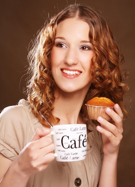 Une jeune femme avec du café et du gâteau.