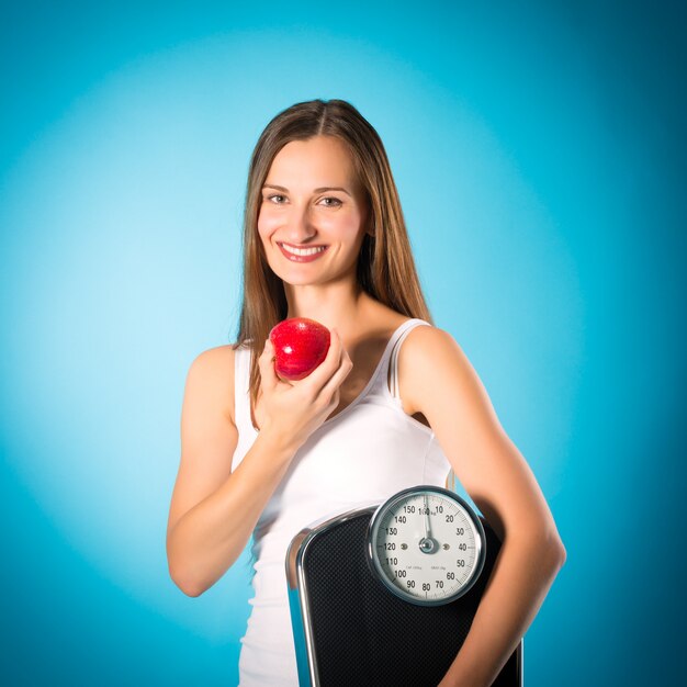 Jeune femme avec une écaille sous le bras et une pomme