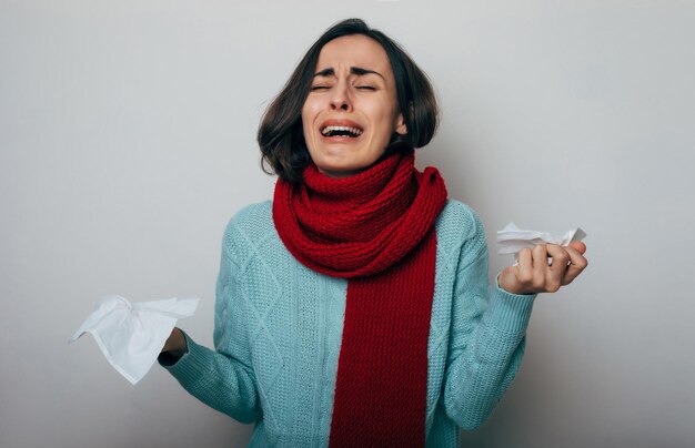 Jeune femme avec une écharpe enveloppée à haute température qui tousse Femme malade avec grippe et maux de tête Concept d'allergie à la maladie du froid rhinite Coup de toux Épidémie de coronavirus