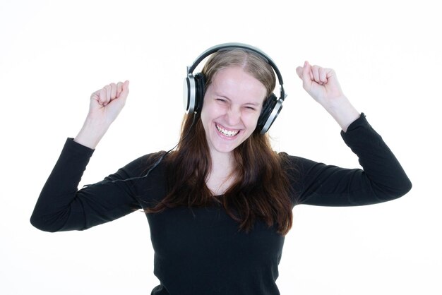 Jeune femme écoutant de la musique dans des écouteurs plaisantant heureux et souriant portrait de belle fille blonde sur fond blanc