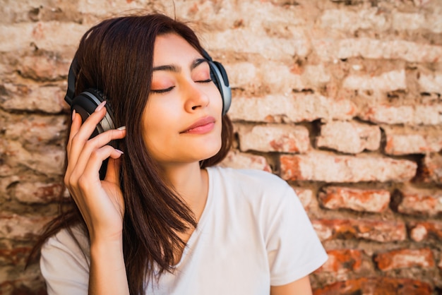 Jeune femme écoutant de la musique avec des écouteurs.