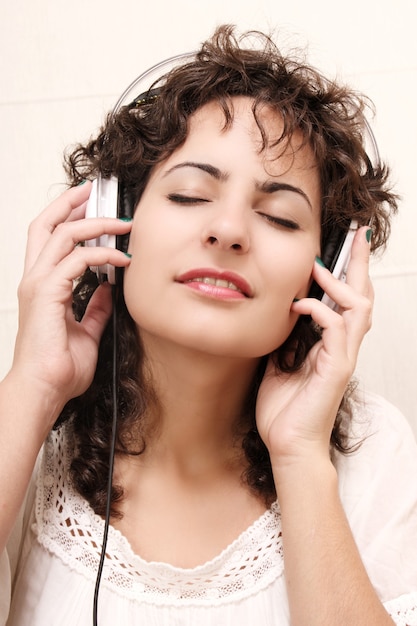 Une jeune femme écoutant de la musique avec des écouteurs.