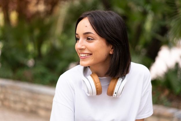 Jeune femme écoutant de la musique à l'extérieur