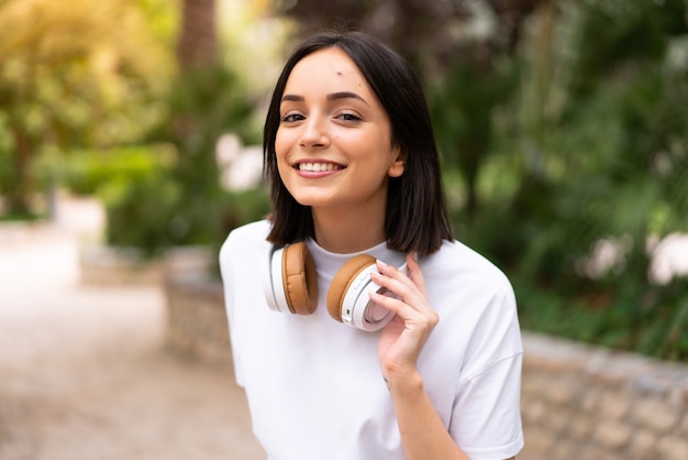 Jeune femme écoutant de la musique à l'extérieur