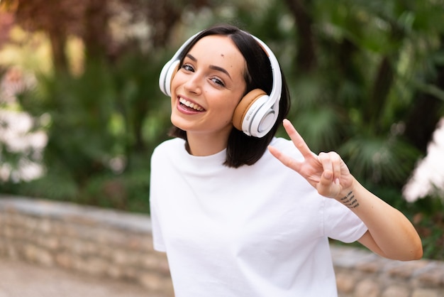 Jeune femme écoutant de la musique à l'extérieur