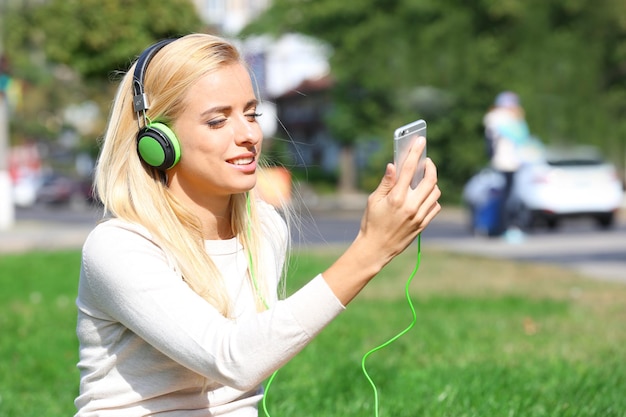 Jeune femme écoutant de la musique à l'extérieur