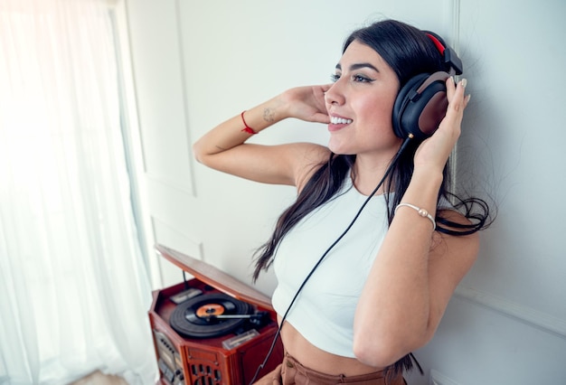 Jeune Femme écoutant De La Musique Avec Une Platine Vintage Dans Le Salon