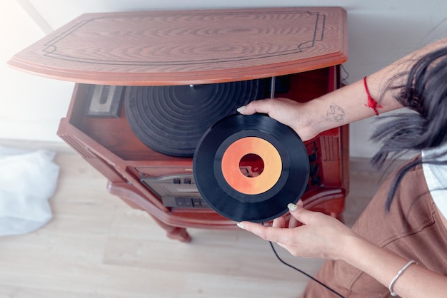 Jeune Femme écoutant De La Musique Avec Une Platine Vintage Dans Le Salon