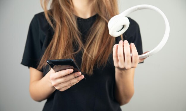 Jeune femme écoutant de la musique avec un téléphone intelligent et un casque sans fil