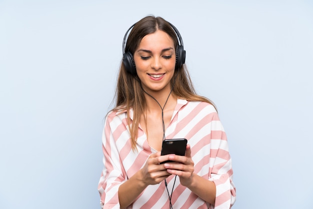 Jeune femme écoutant de la musique avec un téléphone portable