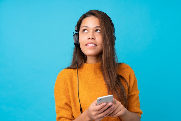 Jeune, femme, écoute, musique, mobile, bleu, mur