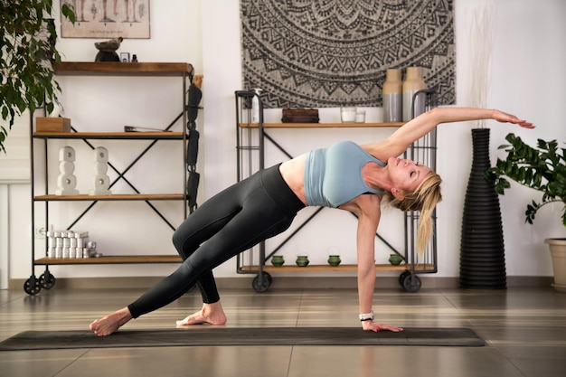 Photo une jeune femme effectuant une pose de yoga sauvage sur un tapis