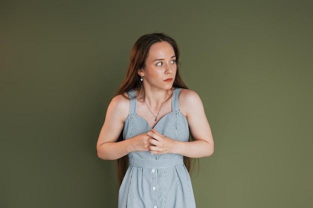 Jeune femme effrayée dans des vêtements décontractés debout à l'intérieur dans le studio