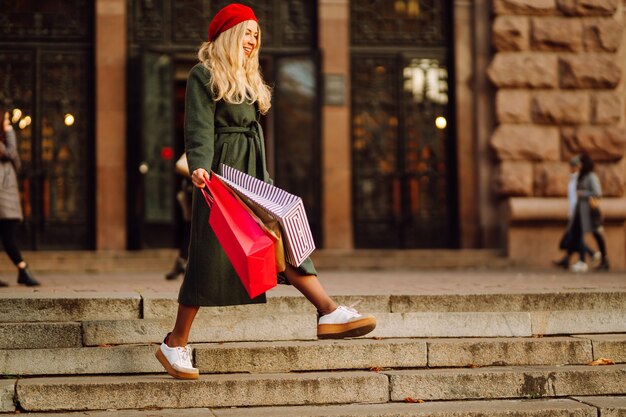 Jeune femme élégante dans des vêtements à la mode avec des sacs à provisions après le shopping Shopping d'automne