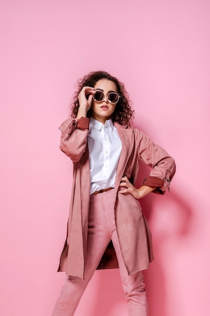 Jeune femme élégante en manteau rose tendance