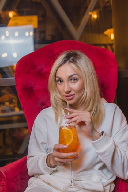 Jeune femme élégante mignonne dans une belle robe brillante sur le restaurant de fond intérieur sombre. Jolie femme posant pour une entreprise de publicité photo.