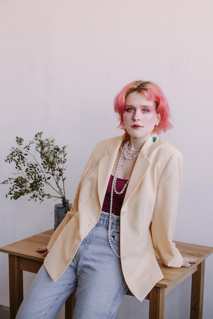 Jeune femme élégante de mode debout maquillage lumineux et cheveux colorés