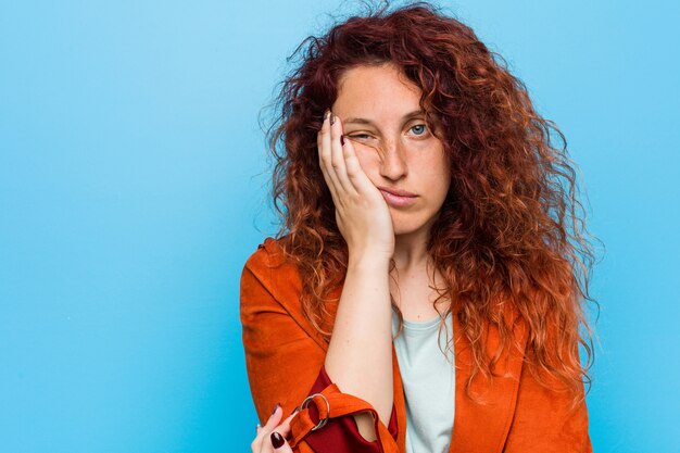 Jeune femme élégante, rousse qui s'ennuie, fatiguée et a besoin d'une journée de détente.