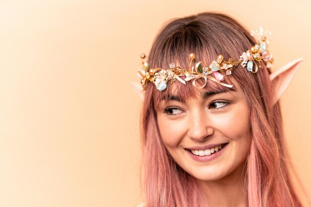 Jeune femme elfe aux cheveux roses isolée sur fond beige