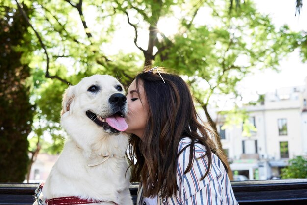 Jeune femme embrassant son chien