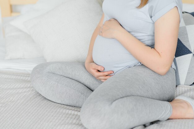 Jeune femme enceinte assise sur un canapé