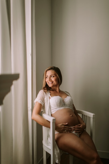 Jeune femme enceinte assise sur la chaise