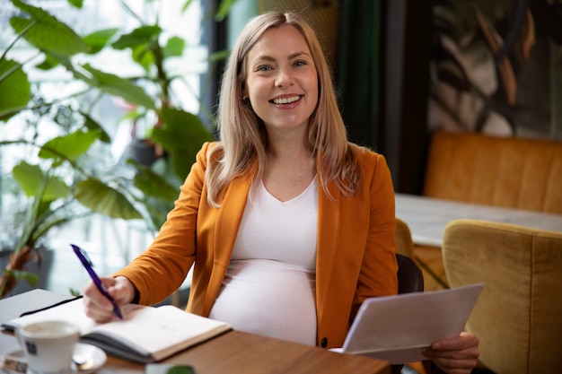 Photo jeune et femme enceinte au travail