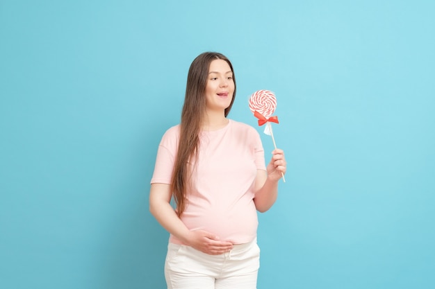 Jeune femme enceinte avec des bonbons à la main