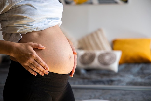 Jeune femme enceinte écoutant son bébé tenant son ventre