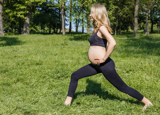 jeune femme enceinte, faire du yoga en jour d'été