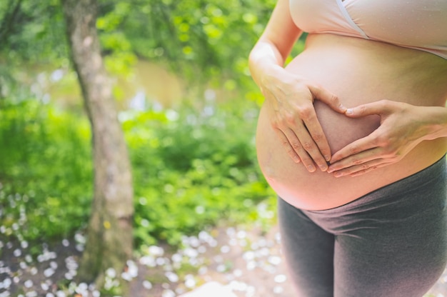 jeune femme enceinte avec gros ventre dans le parc en plein air