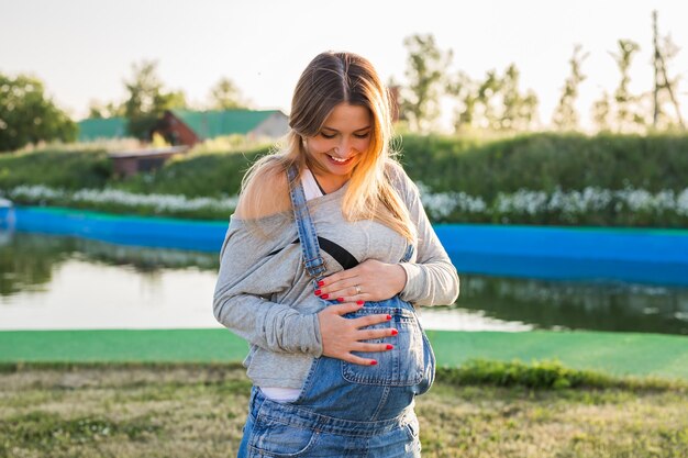 Jeune femme enceinte heureuse se détendre et profiter de la vie dans la nature automnale.