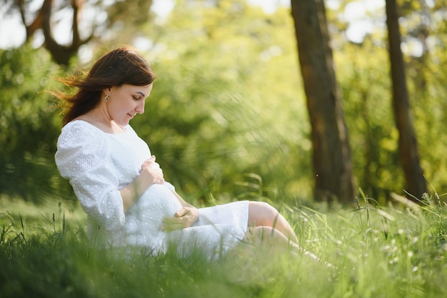Jeune femme enceinte heureuse se détendre et profiter de la vie dans la nature
