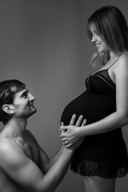 Jeune femme enceinte et homme heureux sur fond