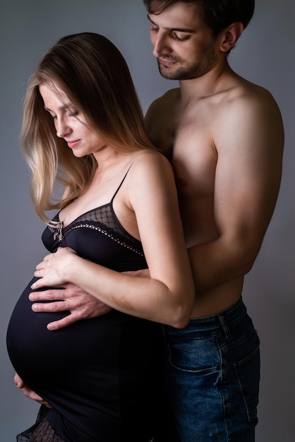 Jeune femme enceinte et homme heureux sur fond