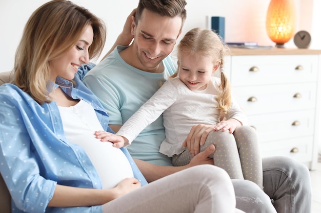 Jeune femme enceinte avec sa famille à la maison