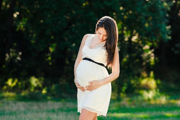 Jeune femme enceinte se détendre dans le parc