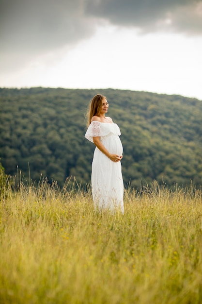 Jeune femme enceinte se détendre à l&#39;extérieur dans la nature